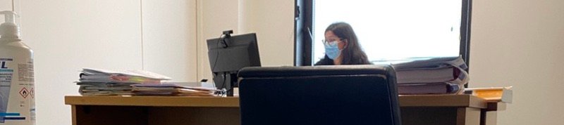 Una cancelleria durante la pandemia: l'impiegata con la mascherina, dietro il divisorio