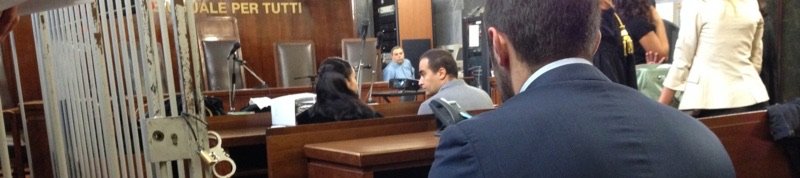 Aula penale con la gabbia degli imputati, sotto la scritta «La legge è uguale per tutti»