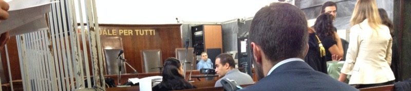Aula penale con la gabbia degli imputati, il pubblico e i difensori